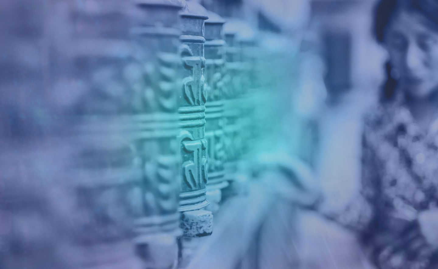 A row of carved metal prayer wheels along a temple wall.